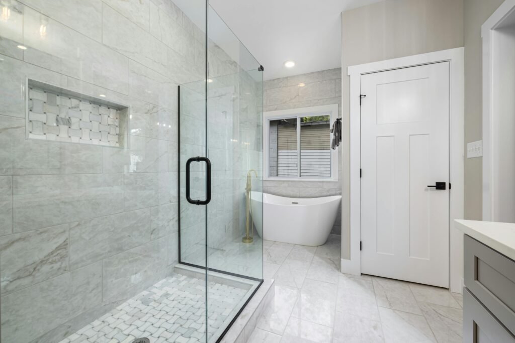 pexels-photo-12119354-12119354-1 Bright modern bathroom featuring a glass shower and freestanding bathtub. Perfect for design inspiration.